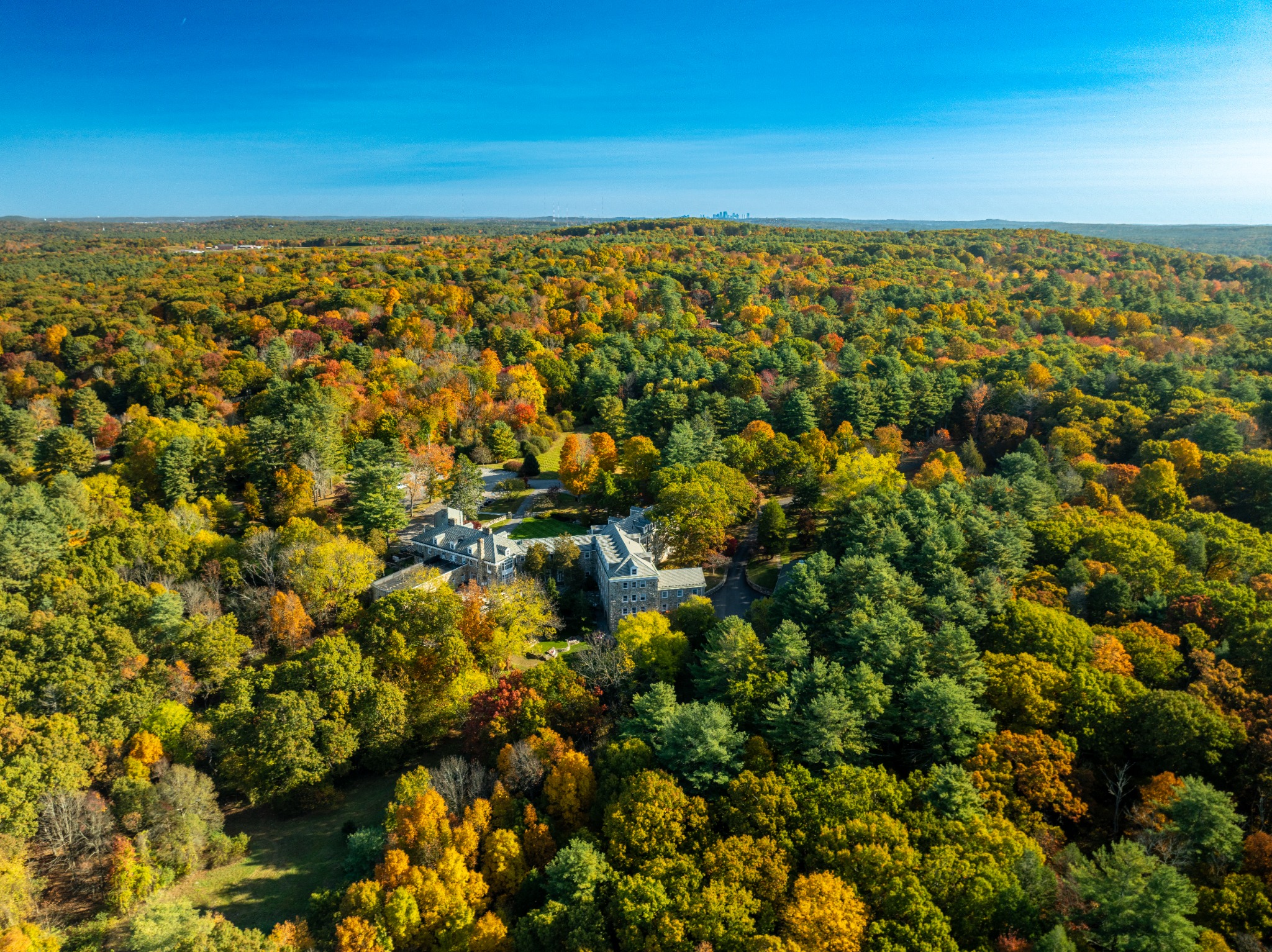 Fall foliage aerial view with Boston skyline in the distance