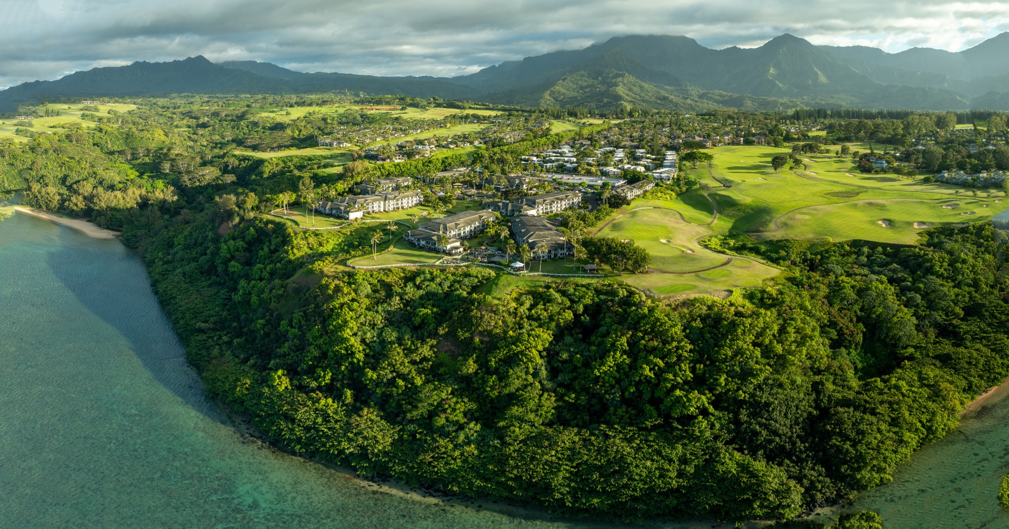 Panoramic aerial landscape with coastline, golf course and mountains